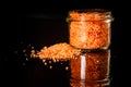 Closeup small glass jar with pile orange organic sea salt Royalty Free Stock Photo