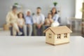 Real estate concept background with a little house and a big family in their new home Royalty Free Stock Photo