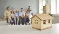 Real estate background with a little toy house and a big family in their new home Royalty Free Stock Photo