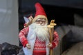 Closeup of a small Santa Claus figure holding wooden skis with a blurry background Royalty Free Stock Photo