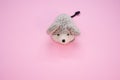 Closeup of a small soft mouse toy on a pastel pink surface for a copy space