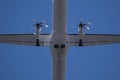 Closeup of a small turboprop passenger aircraft against bright blue sky