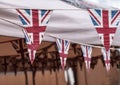 Closeup of small Union Jack flags on strings in a park during a festival