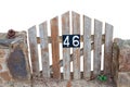 Closeup of a small weathered wooden garden gate with the number 46 on it isolated on a white background. Wooden fence design