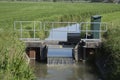 Closeup of a small weir in a stream for water level control in a Dutch polder Royalty Free Stock Photo