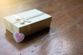 Closeup small white peatl gift box with white ribbon and the pink sparkle tiny heart
