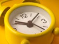 Closeup a small, yellow, retro-style analog alarm clock Royalty Free Stock Photo