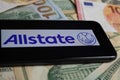 Closeup of smartphone with logo lettering of allstate insurance company on paper money currency Royalty Free Stock Photo