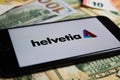 Closeup of smartphone with logo lettering of helvetia insurance company on paper money currency