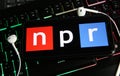 Closeup of smartphone screen with logo lettering of independant online radio broadcast service npr on computer keyboard Royalty Free Stock Photo