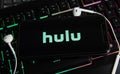 Closeup of smartphone screen with logo lettering online video movie on demand service hulu on computer keyboard