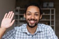 Closeup smiling African guy wave hand start videocall webcam view Royalty Free Stock Photo