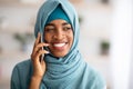 Closeup Of Smiling Black Islamic Lady In Hijab Talking On Mobile Phone