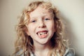 Closeup of smiling Caucasian blonde girl showing her missing lost milk tooth. Dental oral health hygiene. Stage of kids growing up Royalty Free Stock Photo