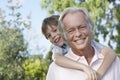 Closeup Of Smiling Grandfather With Grandson Riding Piggyback