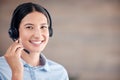 Closeup of smiling mixed race call centre agent smiling while wearing headset. Female customer service representative Royalty Free Stock Photo