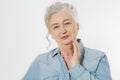 Closeup of smiling senior woman wrinkle face and gray hair. Old mature lady touching her wrinkled skin isolated on white Royalty Free Stock Photo