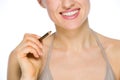 Closeup on smiling woman holding brown eye liner Royalty Free Stock Photo