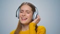 Closeup smiling woman listening music in headphones on grey background. Royalty Free Stock Photo