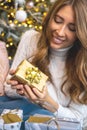 Closeup smiling young blonde woman holding luxury golden Christmas gift box celebrating holiday Royalty Free Stock Photo