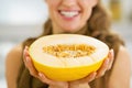 Closeup on smiling young housewife holding melon slice Royalty Free Stock Photo