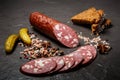 closeup smoked salami sausage with rye bread and pickled cucumbers