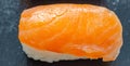 Closeup of smoked salmon nigiri prepared by a Japanese chef in a restaurant