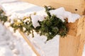 Closeup of the snow-covered veranda of house decorated with New Year branch of pine on sunny winter day. Christmas Royalty Free Stock Photo