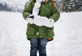 Closeup on snow in hands of child in green coat