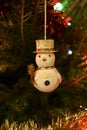 Closeup of a snowman Christmas tree decoration hanging on a Norwegian spruce