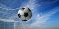 Closeup of soccer ball in goal net. Football play in front of blue sky background. Sport game championship background Royalty Free Stock Photo