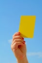 Closeup of soccer referee hand holding yellow card Royalty Free Stock Photo