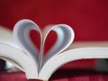 Closeup soft focus pages of a book curved into a heart shape. Royalty Free Stock Photo