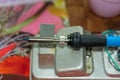 Closeup soldering iron on metal stand on the table. Process of engineering work . Neb of technich instrument tool Royalty Free Stock Photo