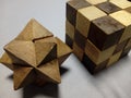 Closeup of a solved cube and star wooden puzzle on a gray surface Royalty Free Stock Photo