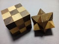 Closeup of a solved cube and star wooden puzzle on a gray surface Royalty Free Stock Photo