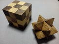 Closeup of a solved cube and star wooden puzzle on a gray surface Royalty Free Stock Photo