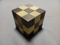 Closeup of a solved wooden puzzle cube on a gray surface Royalty Free Stock Photo