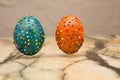 Closeup of some homemade easter eggs, made by myself by gluing some pieces of different papers, drying attached to wooden sticks .