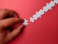 Someone hand holding white puzzle on a red background Royalty Free Stock Photo