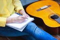 Closeup songwriter writing on note paper with acoustic guitar ne Royalty Free Stock Photo