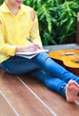 Closeup songwriter writing on note paper with acoustic guitar ne Royalty Free Stock Photo