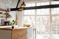 Closeup of a spacious loft industrial open space kitchen studio interior with big windows and sunlight in the morning