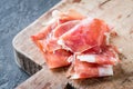 Closeup of Spanish ham jamon serrano or Italian prosciutto crudo on old wooden board Royalty Free Stock Photo