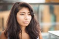 Closeup of a Serious young Spanish woman looking at the camera. She is sad outside.