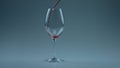 Closeup spirituous liquid splashing inside wineglass. Wine pouring clean goblet