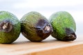 Closeup of spoiled rotten avocado on rustic background