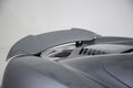 Closeup of a spoiler on a dark modern sports car under the lights isolated on a grey background