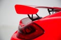 Closeup of a spoiler on a red modern sports car under the lights isolated on a grey background