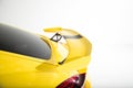 Closeup of a spoiler on a yellow modern car under the lights isolated on a white background
